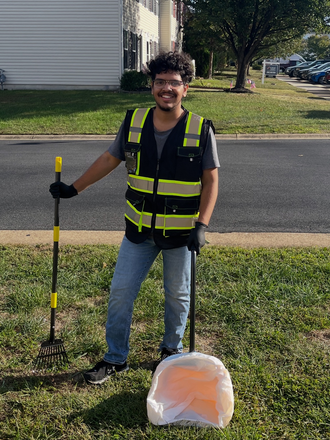 Jonathan from Poop Patrol standing with rake and bin
